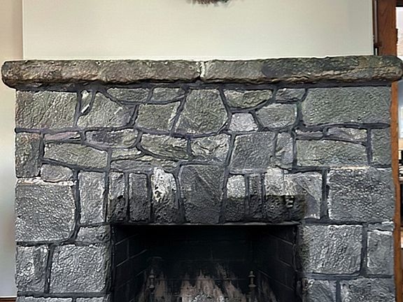 Historic fireplace (aesthetic only) made of local granite imported from Port Deposit. Located in living room on first floor (photo edited with AI to remove decor)