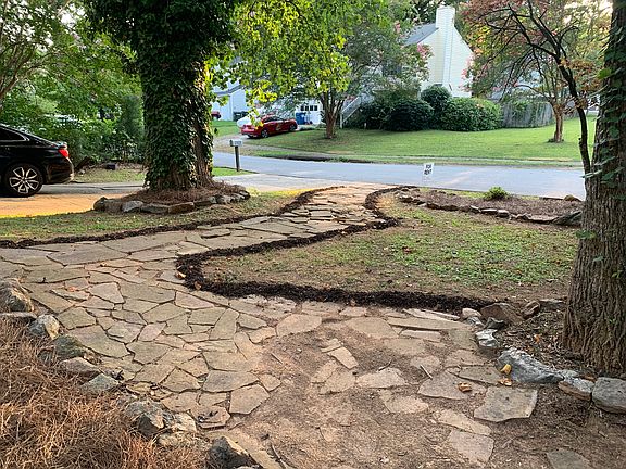 Front yard with stone borders and stone walkways.