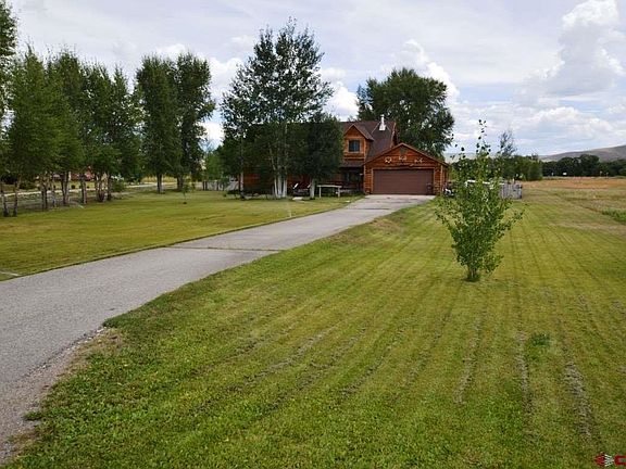 Entrance to front of house on paved asphalt driveway to 2 car detached garage.