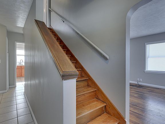 Entry leads to kitchen, upstairs to bedrooms 3 and 4 and the 1/2 bath, living room on the right and the primary bedroom, second bedroom and main bath to the left.