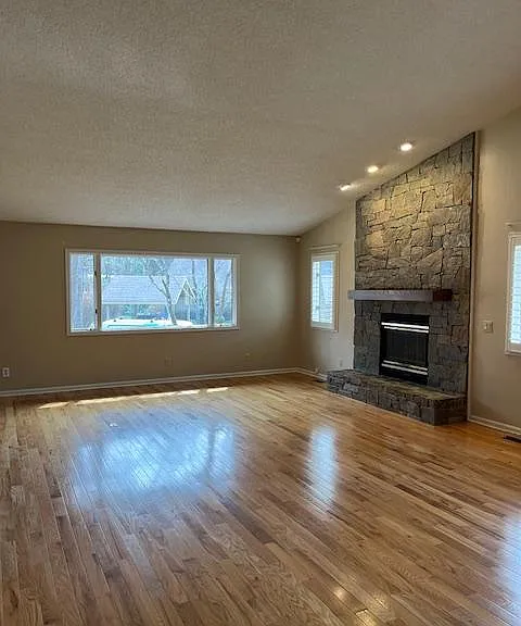 Great Room with beautiful stone fireplace with gas logs. side of unit has plantation shutters.