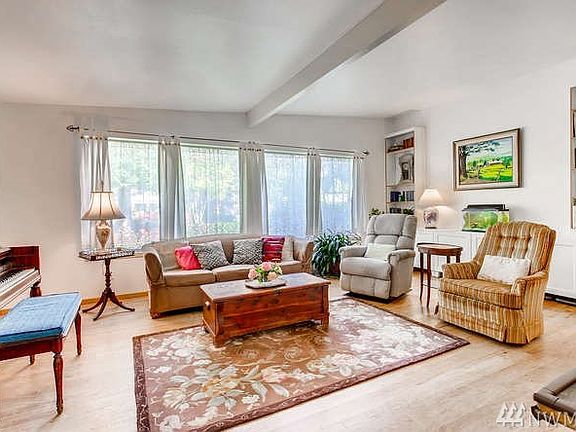 The home still has it's original hardwoods which could use a little love.   This wall of windows really makes a statement in the room and the landscape out front provides a certain amount of privacy.