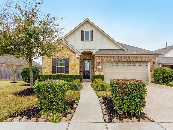 Pretty landscaping borders the front walkway to the covered porch and front entry and the wide driveway leading to the garage offers plenty of off-street parking for homeowners and guests.