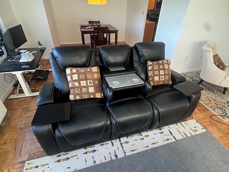 The sofa is equipped with many features. This is the middle console of a table with two cup holders.