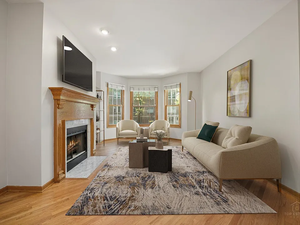 Open living room / dining layout with gas fireplace and bay windows - staged