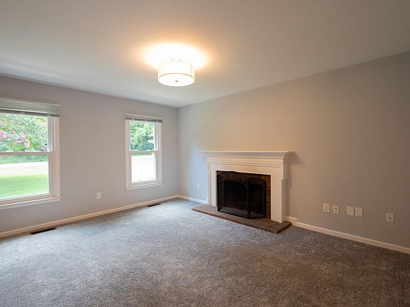 Sitting room with fireplace and new carpet.