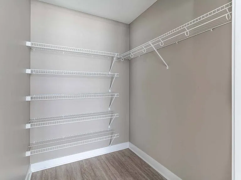 Large walk-in closet off primary bedroom with shelving and clothing rods