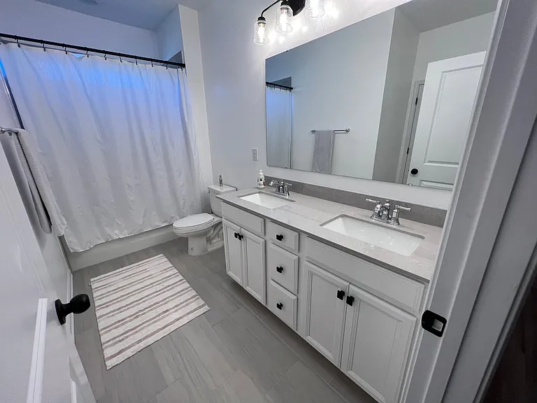 4th bedroom connected shared bath with dual granite vanity and tub shower.