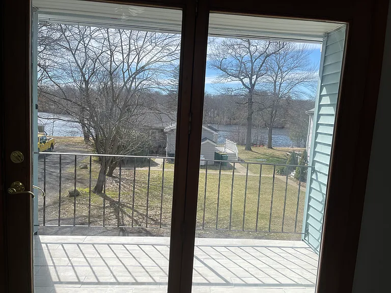 Balcony outside master suite with view of pond and sunset