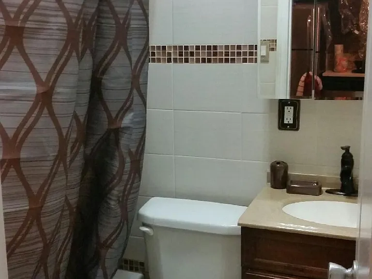 Full bath with shower/tub combo, tile surround, and convenient fixtures for everyday use + window for ventilation & light.