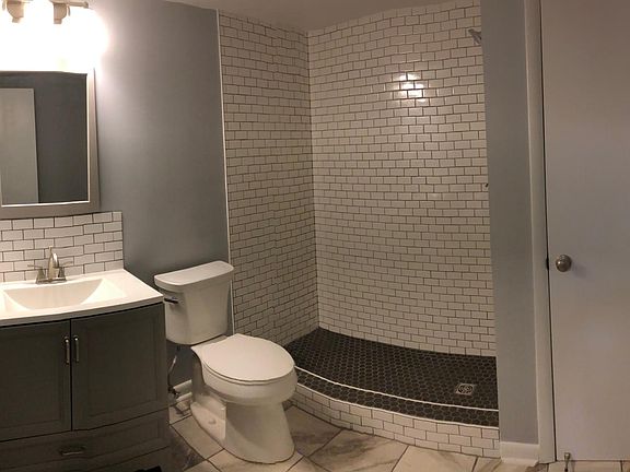 Beautifully renovated bathroom with subway tile shower, ceramic tile flooring, vanity with subway tile backsplash, and spacious linen closet