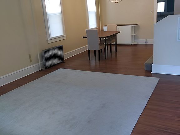 Another, furnished view of the large (approximately 27 x 13 feet) living room / dining room combination space. The front half of the room is considerably wider than this photo captures. View from the front door.