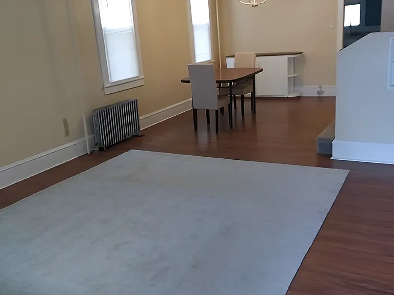 Another, furnished view of the large (approximately 27 x 13 feet) living room / dining room combination space. The front half of the room is considerably wider than this photo captures. View from the front door.