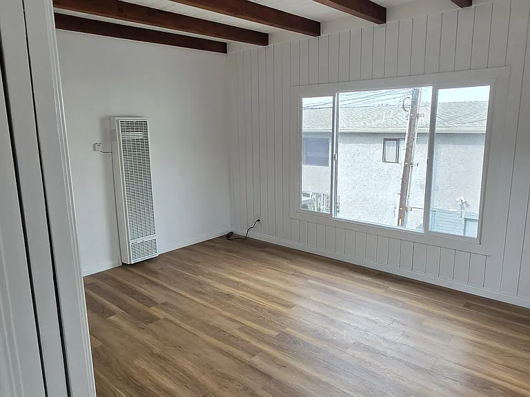 Living room with new floors, new large window, peak view of PV off to the south.