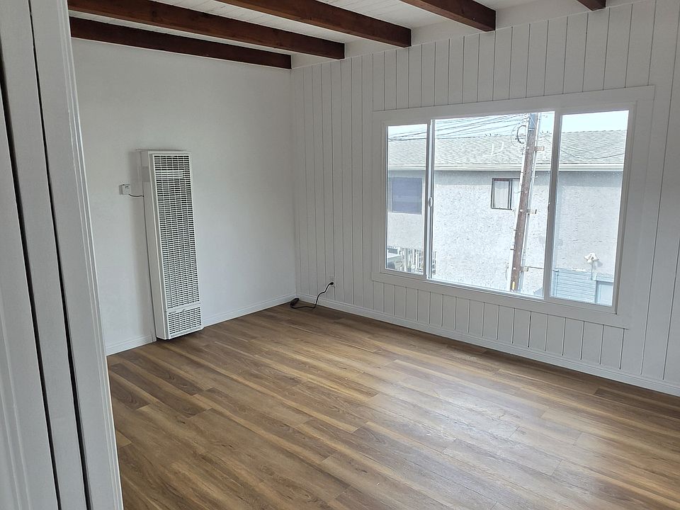 Living room with new floors, new large window, peak view of PV off to the south.