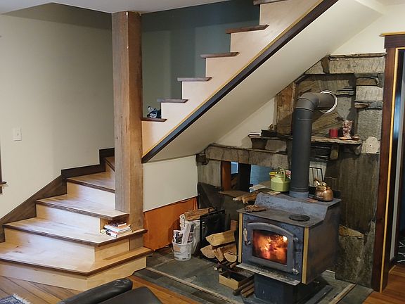 Living area with Kuma Wood heater, stone hearth, bamboo floors...Stairway winding to upstairs bedroom