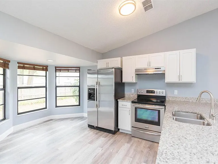 Our kitchen features a dining area and modern appliances, perfect for preparing and enjoying home-cooked meals.
