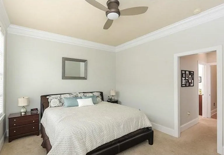 Master bedroom featuring a ceiling fan, crown molding, a window with blinds, and neutral carpeting