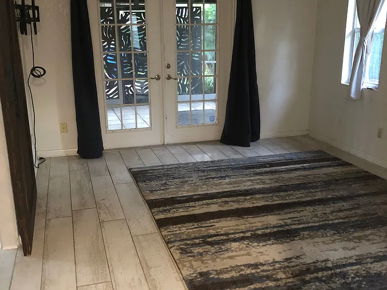 Master bedroom with carpet looking out towards screen porch