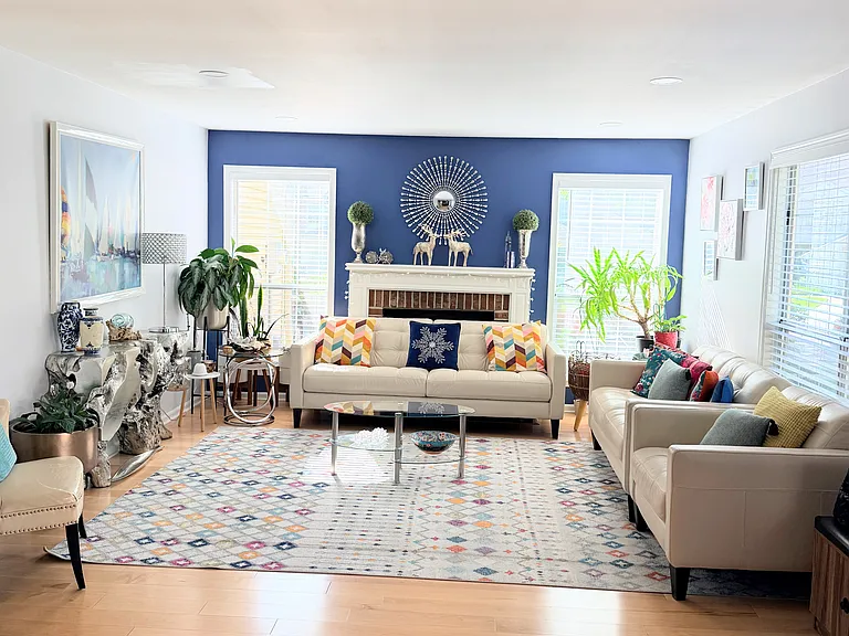 The right side of the entrance on the main level is the living area with a fireplace. Three large windows get beautiful sunlight for indoor plants.