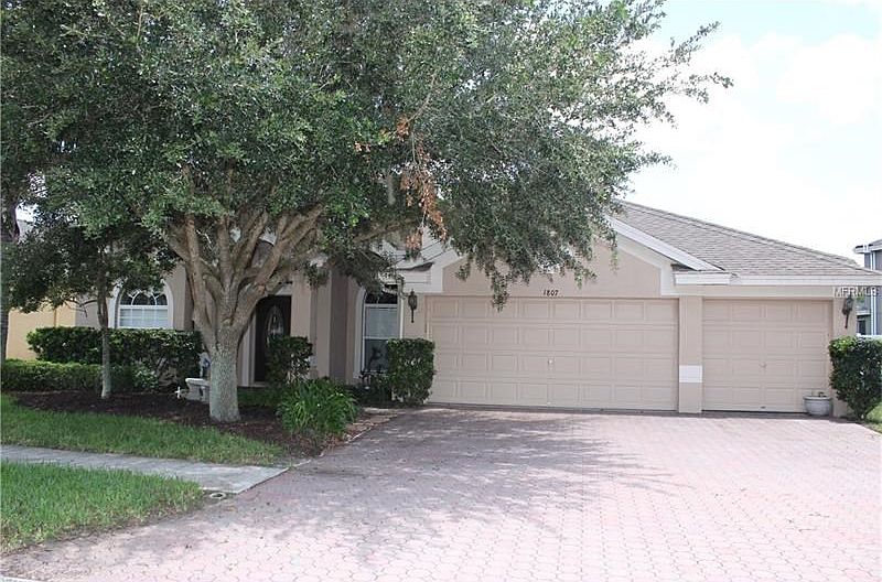 Front of home with brick driveway