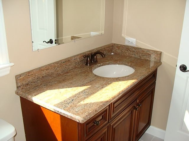Second full bath with new cabinet, lighting, tile, and granite