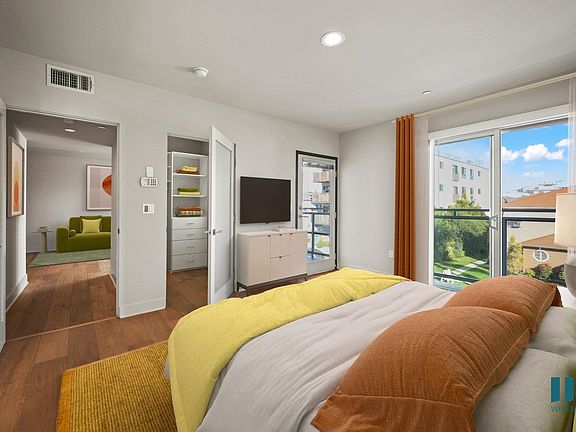 Primary Bedroom with a Balcony, Walk-In Closet with Built-In Organizers, Recessed Lighting, and Vinyl Flooring