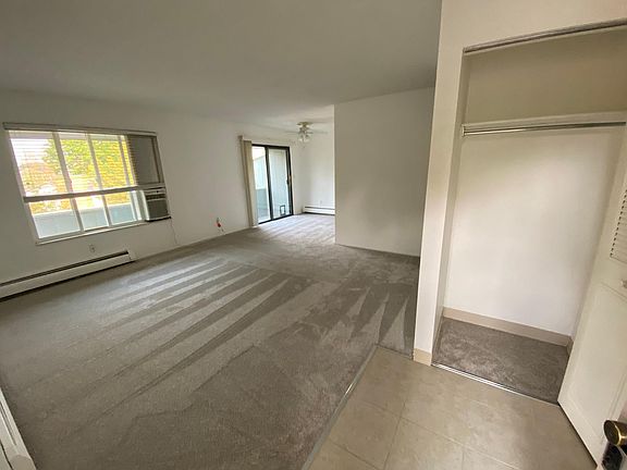 View from front door into the unit. Notice the large windows, lots of light, ceiling fan and large entry closet.