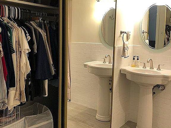 Full size mirrored closet in spacious bathroom.