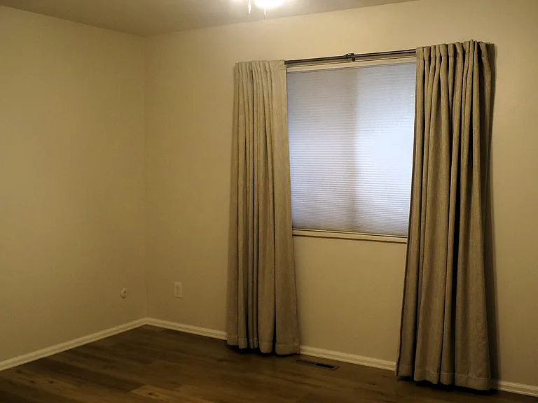 12' X 15' Primary bedroom has honeycomb blinds and blackout thermal curtains.