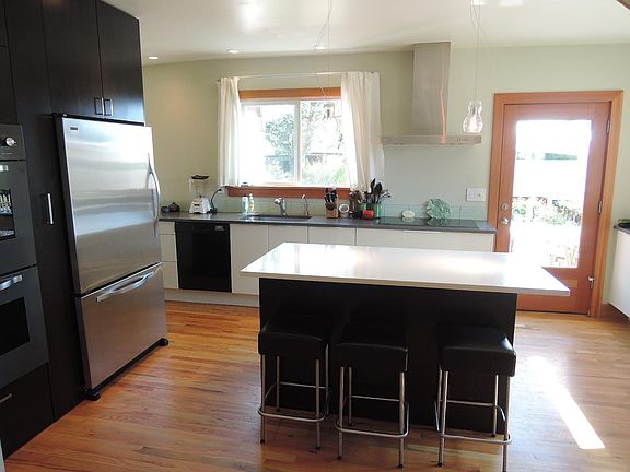 Large kitchen island and double oven. Door to back yard and deck.