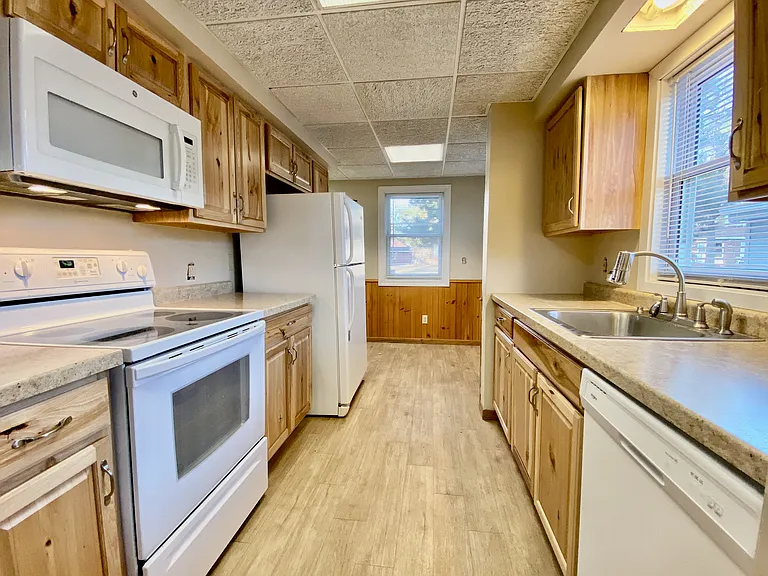 Inviting kitchen with natural wood cabinetry, modern appliances, and ample counter space, filled with warm natural light. Inviting kitchen with natural wood cabinetry, modern appliances, and ample counter space, filled with warm natural light.