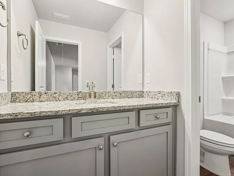 Secondary bathroom with double vanity and shower/tub combo