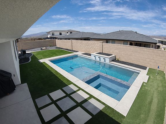 Beautifully landscaped yard with private pool, turf, covered patio and putting green.