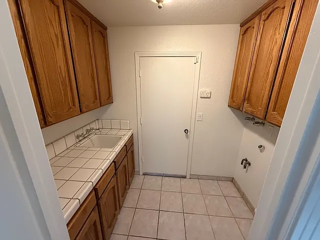 Laundry room off hallway with garage access