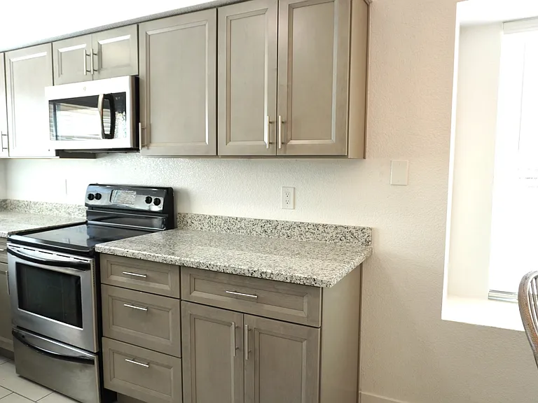 Kitchen with newer cabinets, easy care granite counter tops, sink, dual pane windows.