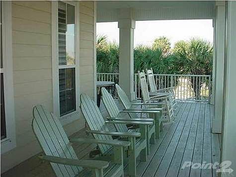 Welcoming front porch is the a great place to sit and visit and listen to the soothing surf.