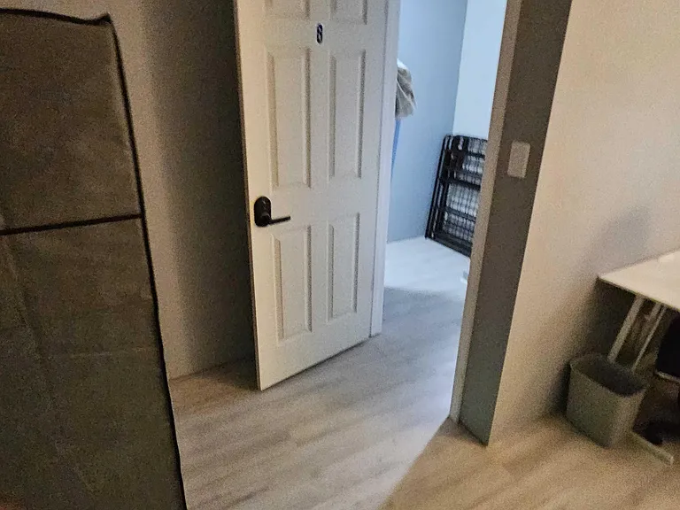 Private bedroom with durable flooring and space for a bed plus a dedicated desk setup for work or study.