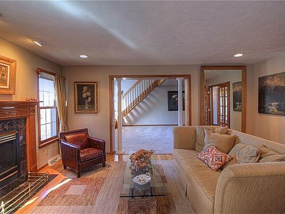 The living room features a marble hearth fireplace and grand columns leading into the family room!