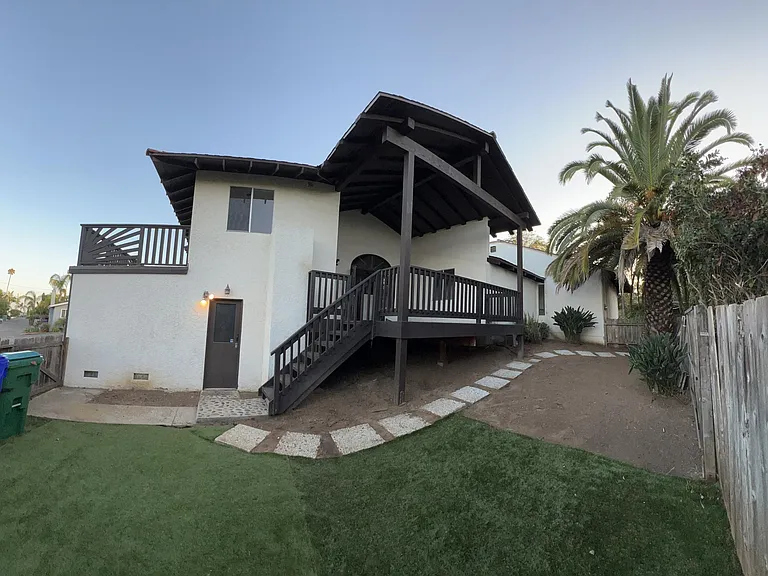 spacious fenced backyard and rear entrance into below garage with upper deck off of kitchen