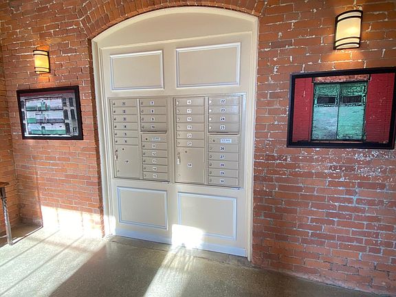 Locked mailboxes inside of the building with large compartments for packages.