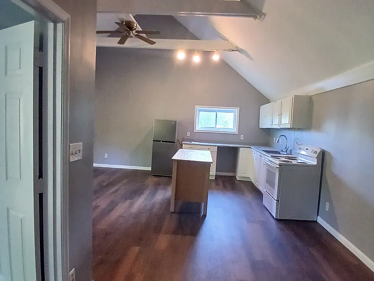 Bedroom door on left, kitchen straight ahead, leading to living room area