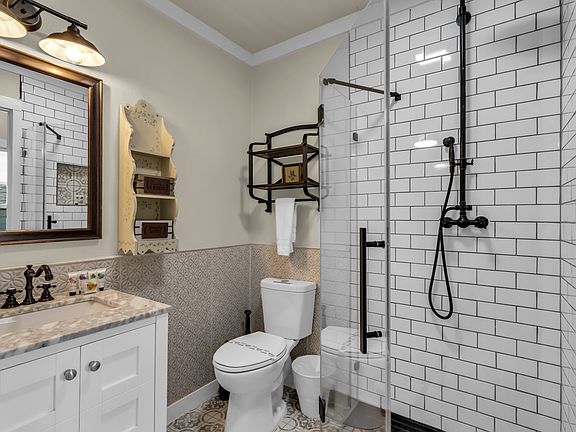 The master bedroom has a barndoor opening into its ensuite walk-in tiled shower with walk in closet access to the right.