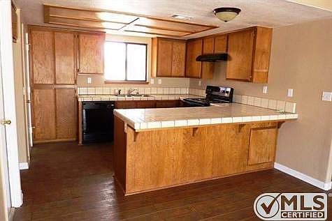 Kitchen with breakfast bar. Looks thru dining area with sli
