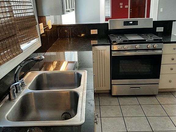 Kitchen looks through dining area and living room to front door