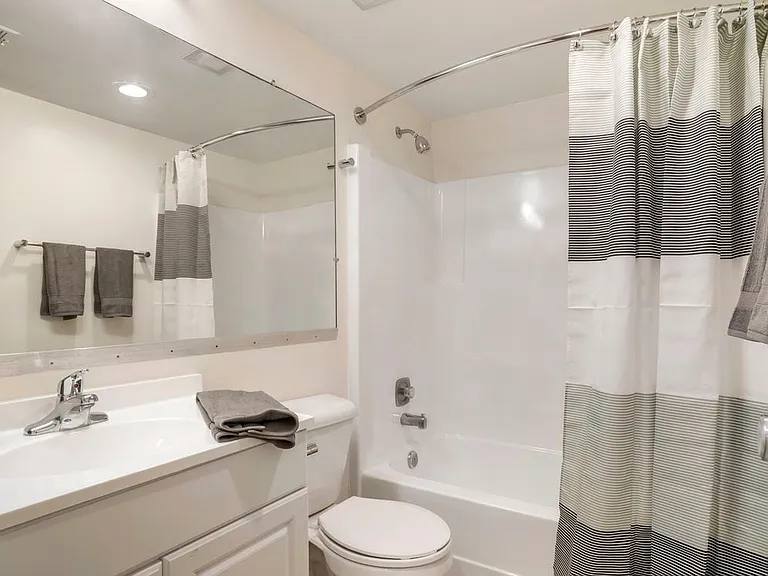 Renovated Package II bath featuring white cabinetry and countertops