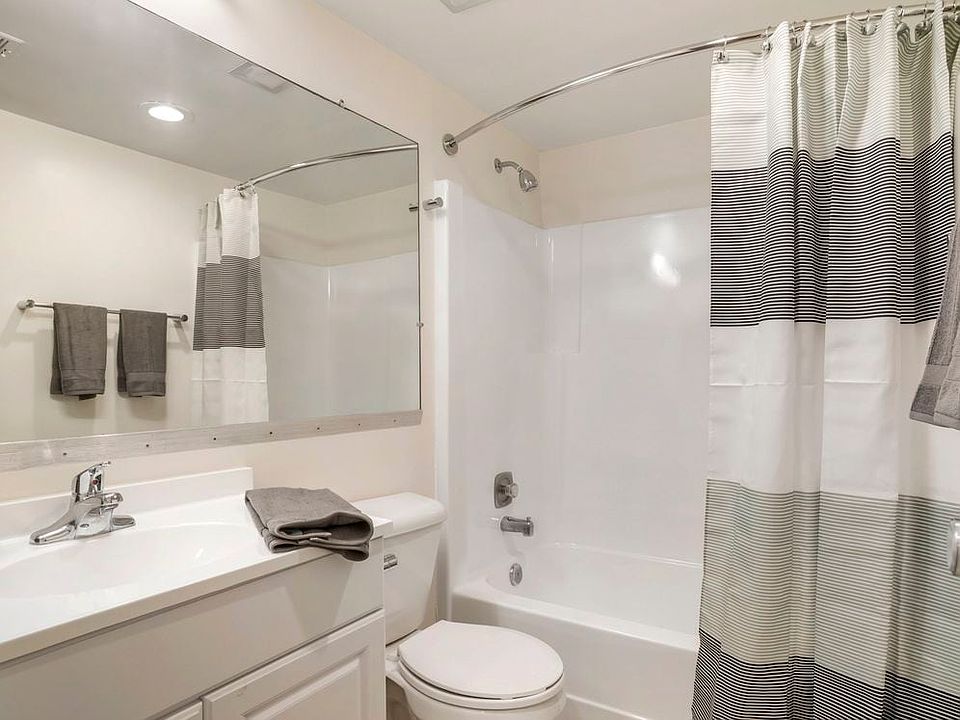 Renovated Package II bath featuring white cabinetry and countertops