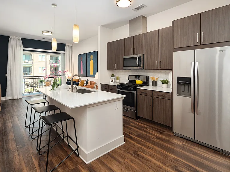 Modern Open Kitchen with Island Seating, Stainless Steel Appliances, and Wood-Style Flooring