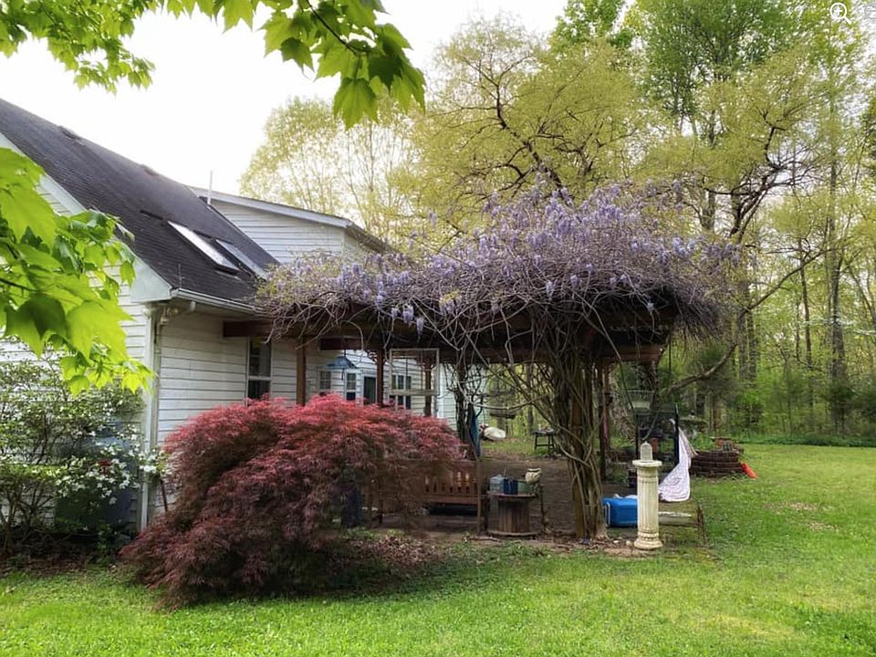 Rear with a patio in spring. 2 Skylights are over the Kitchen.