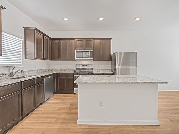 Chef-ready kitchen with a large island, stainless appliances, and granite countertops.